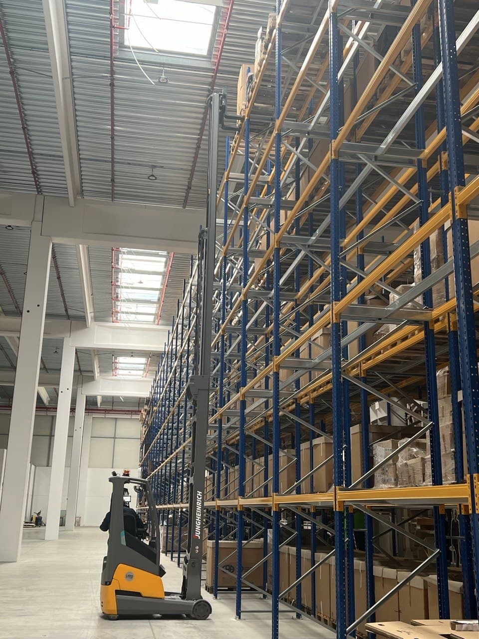 Interno magazzino MOVI.LOG con scaffalature industriali e muletto